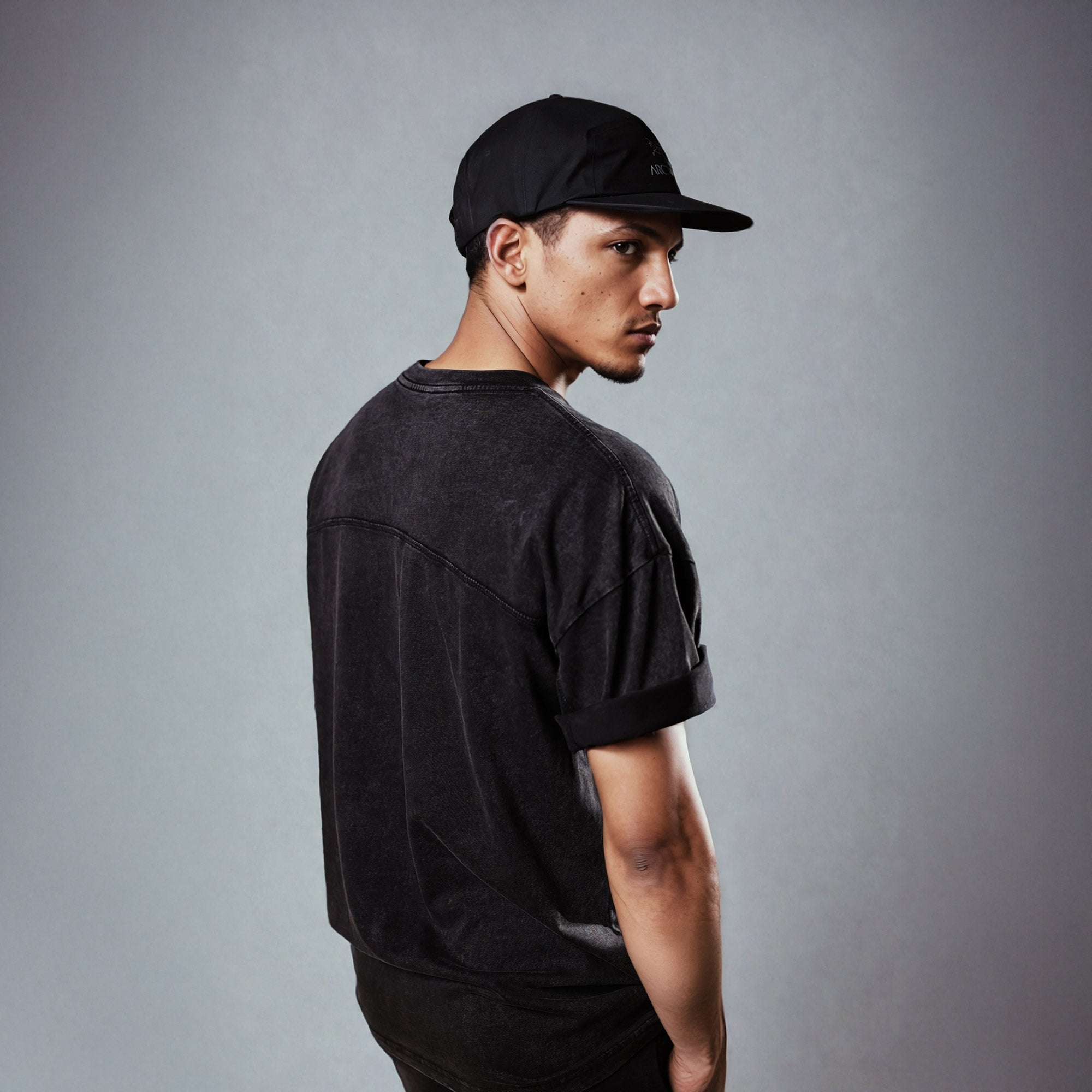 Man wearing black stone washed t-shirt and cap showcasing the Wellness Bundle (Mens) apparel from behind.