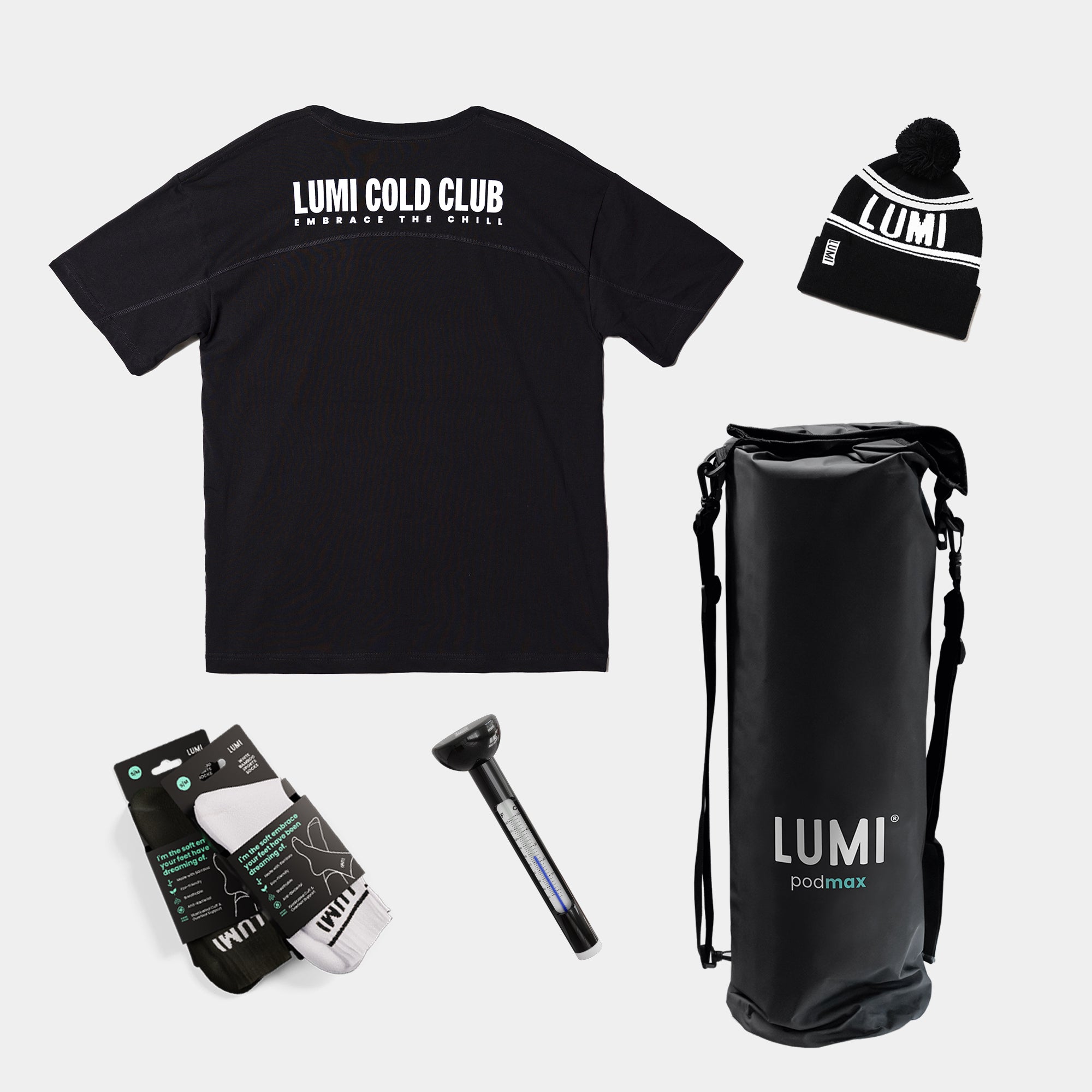 LUMI Cold Bundle featuring black oversized t-shirt with LUMI Cold Club logo, black pom beanie, waterproof dry bag, bamboo socks, and thermometer displayed on white background. Essential cold therapy gear set in monochrome design.