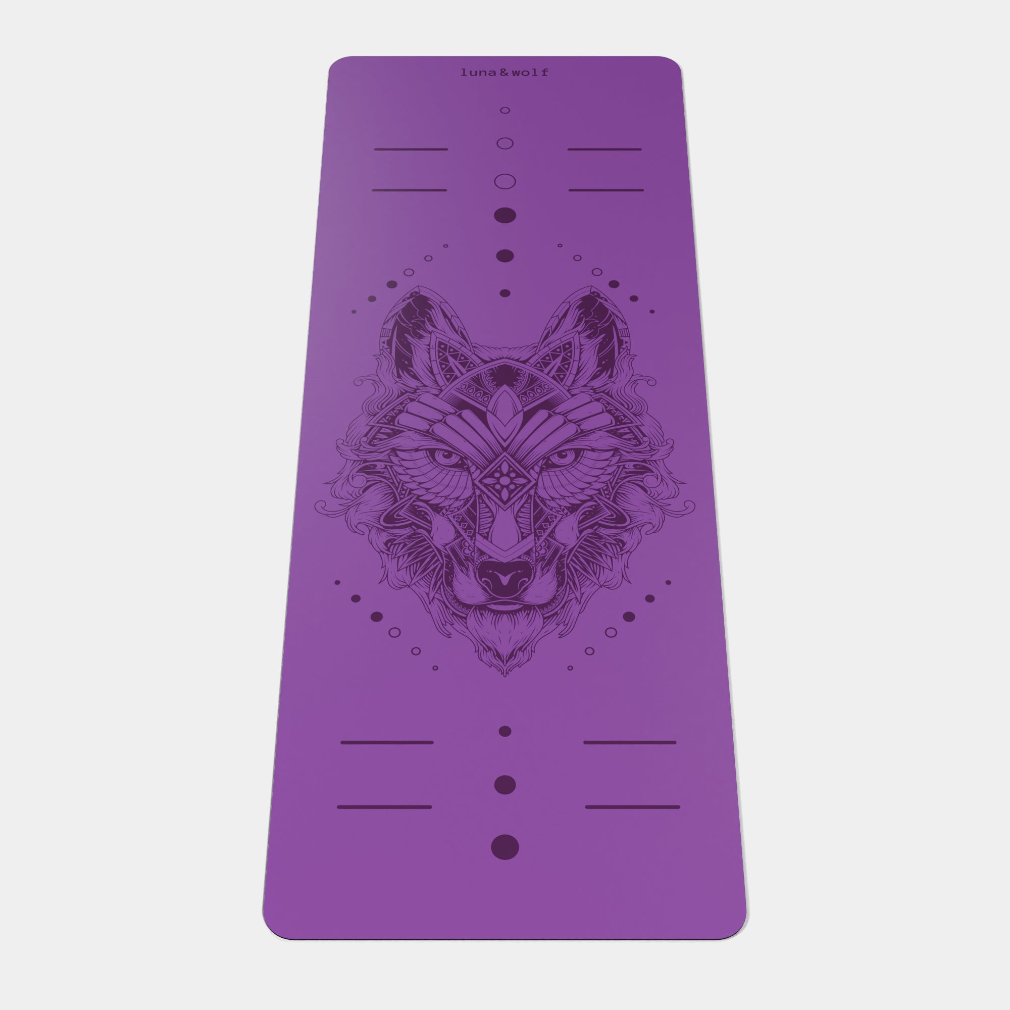 Eco Wolf Yoga Mat featuring an intricate geometric wolf head design centered on a vibrant purple non-slip surface. Premium 4mm thick mat with alignment markers and Luna & Wolf branding at the top. The mat displays a detailed mandala-style wolf illustration with decorative dots and lines.