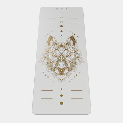 Eco Wolf Yoga Mat - Gold Edition featuring a white mat with intricate geometric wolf head design in metallic gold, alignment markers, and Luna & Wolf branding. Premium non-slip exercise mat with artistic positioning dots and lines.