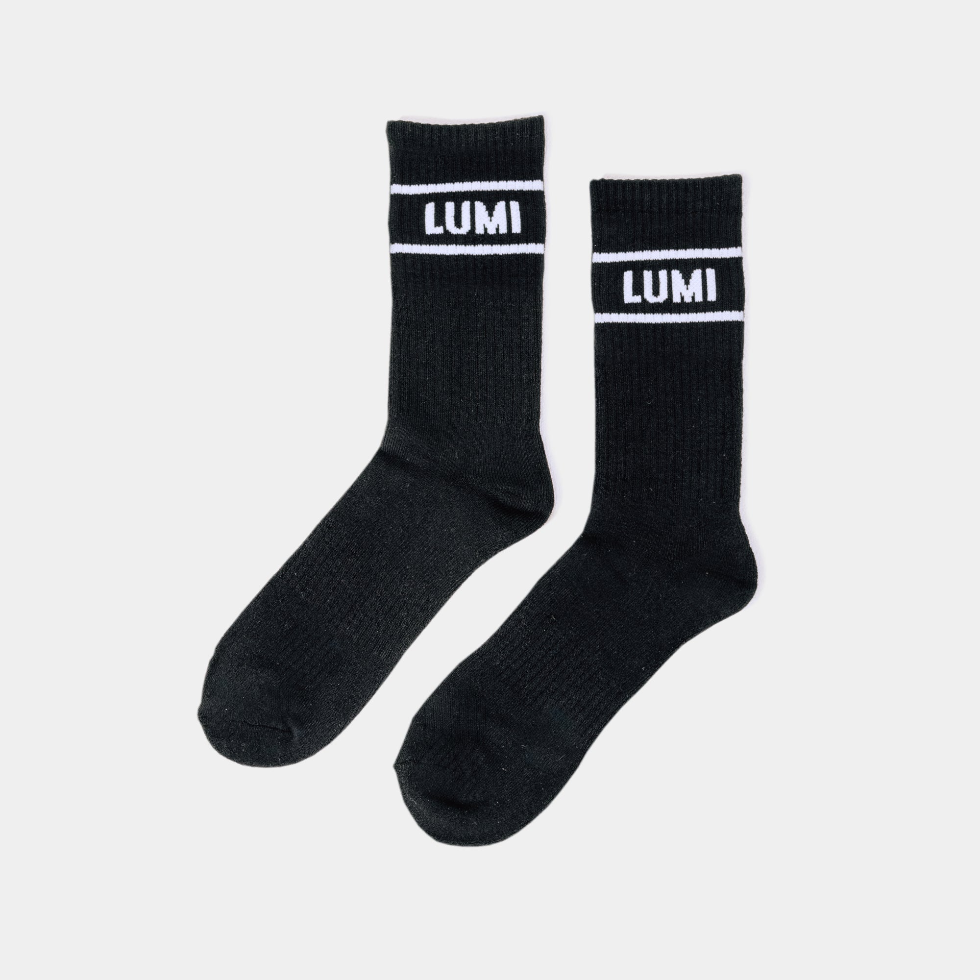 Pro Bamboo Socks with Stripes - Black athletic socks featuring white LUMI logo and striped design, displayed flat against white background. Made from eco-friendly bamboo material with elasticated support and crew length cut.